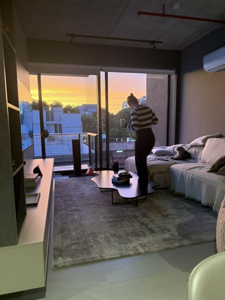 Sala de apartamento com o pôr do sol entrando pela janela